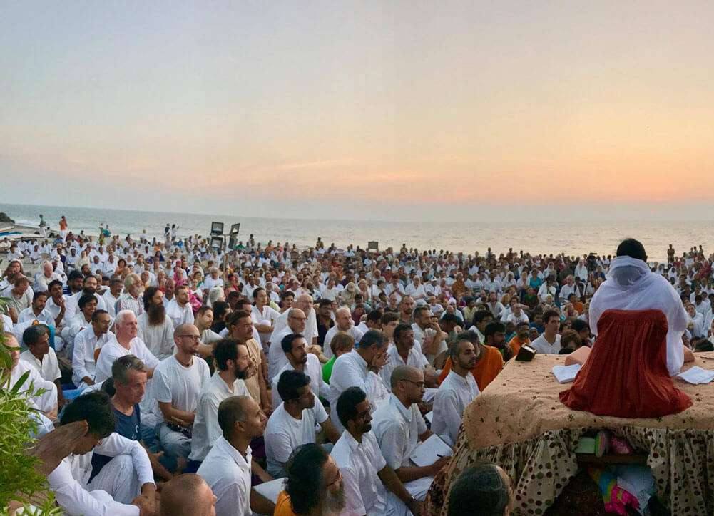 Amma with devotees at the seashore at dusk