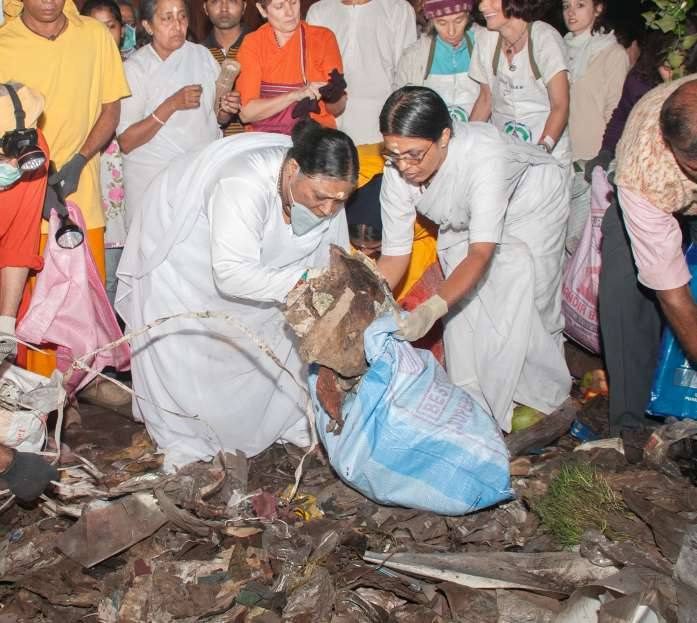 Amma and volunteers filling sacks with waste