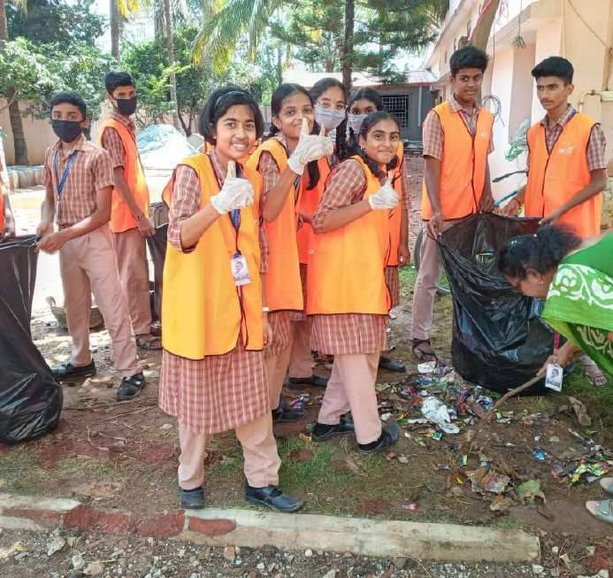 Students in orange vests at a clean-up