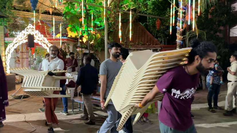 Volunteers carrying stacked chairs