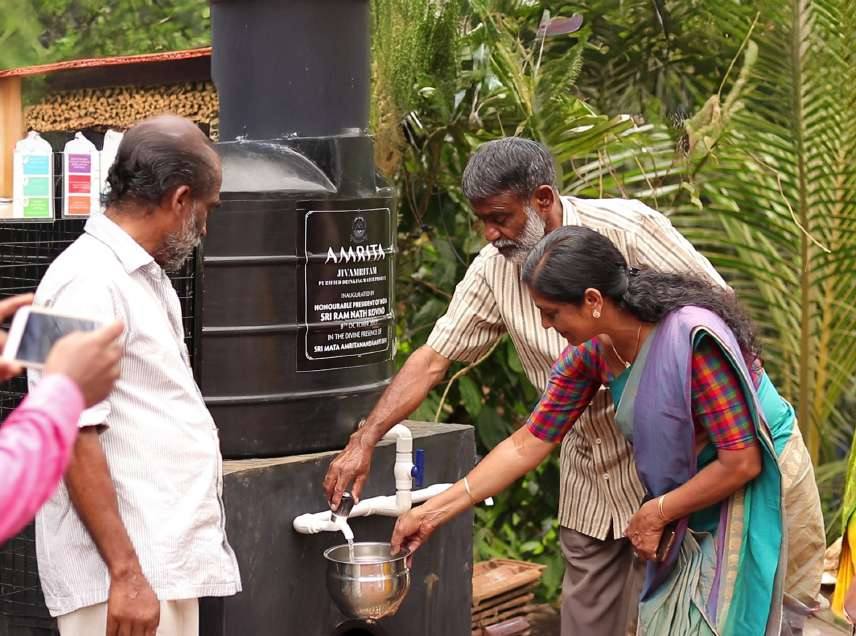 Villagers collecting water from a Jivamritam filter unit